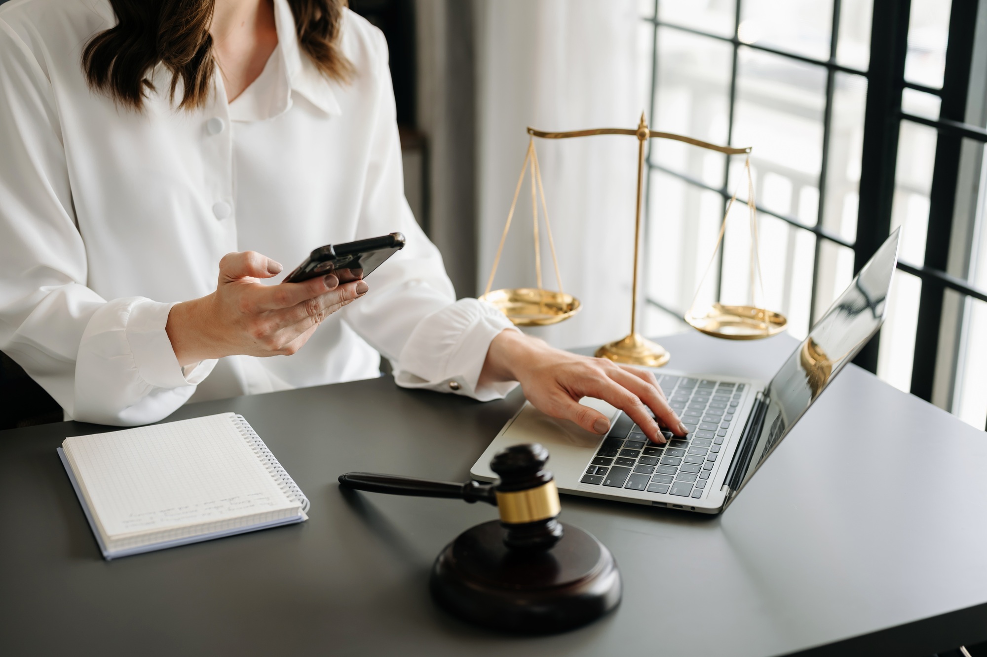 justice and law concept.Male judge in a courtroom the gavel, working with smart phone and laptop