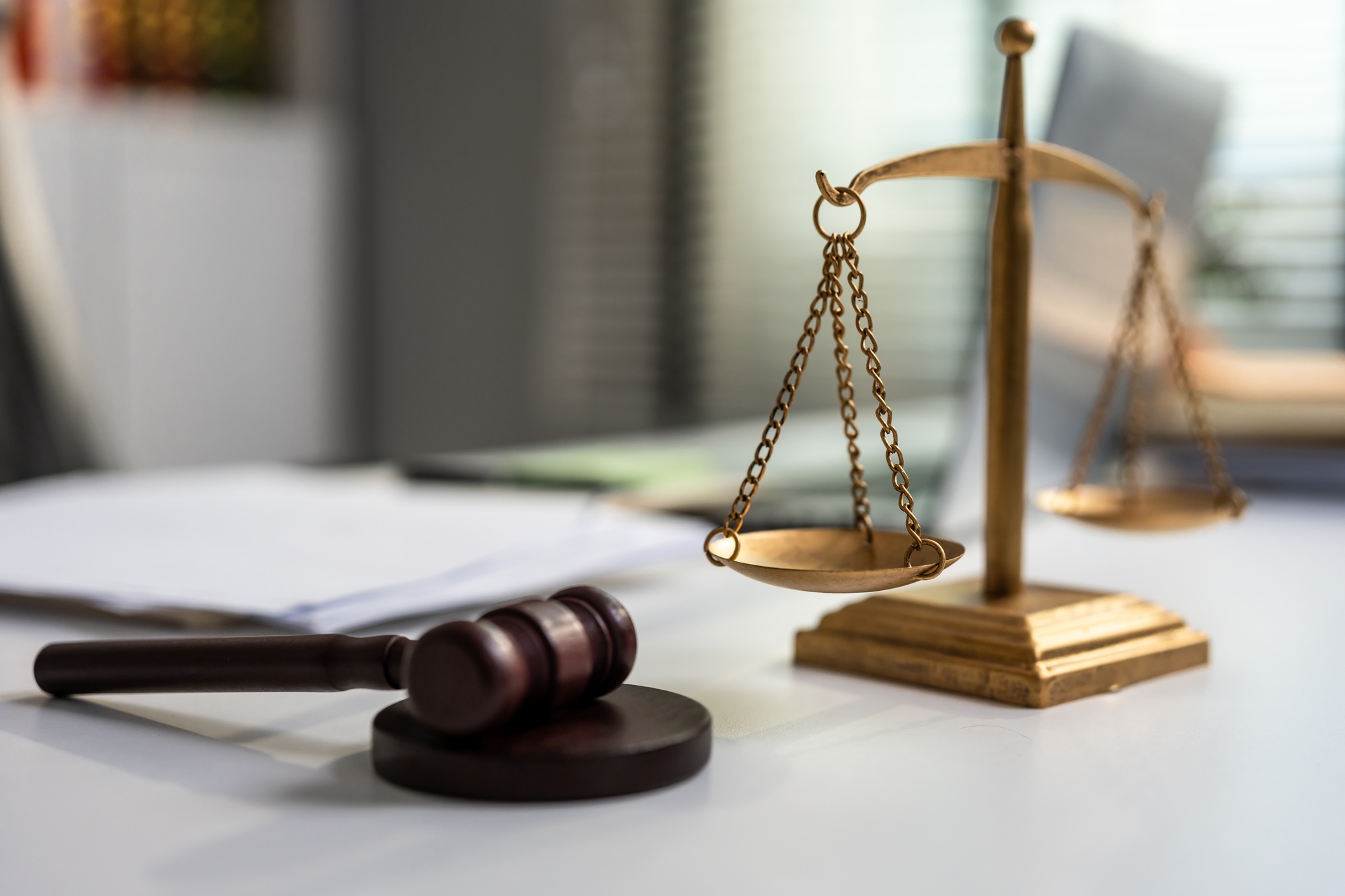 Shot of lawyer hammer and equality scales of justice in courtroom.